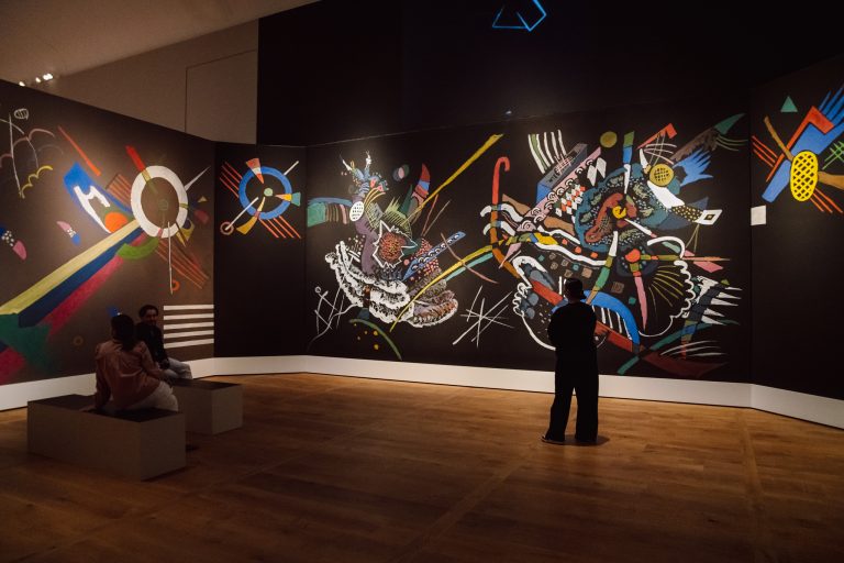 Zaalimpressie van de Kandinsky-tentoonstelling in H'ART Museum. Op de foto zie je bezoekers door de reconstructie van de Salon lopen.